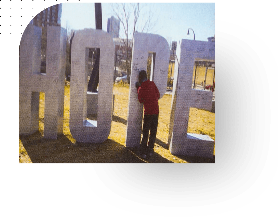 A person standing next to large letters that spell out " hope ".